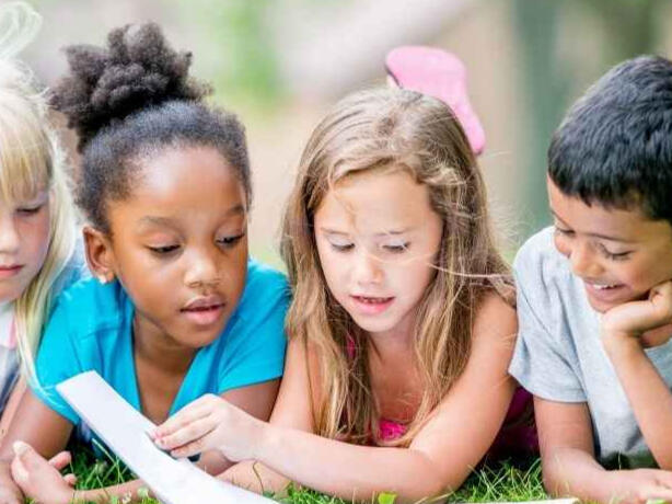 Kids reading on the lawn.